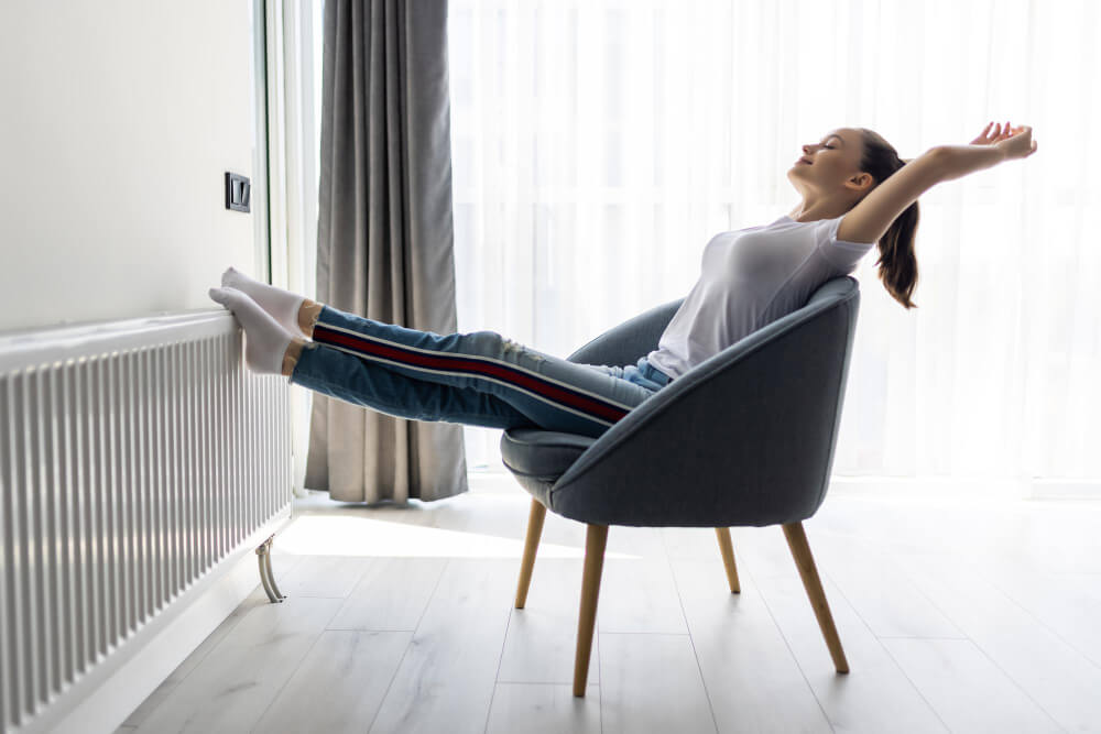 Canapé placé à une distance raisonnable d'un radiateur mural, avec une tablette au-dessus pour dévier la chaleur.