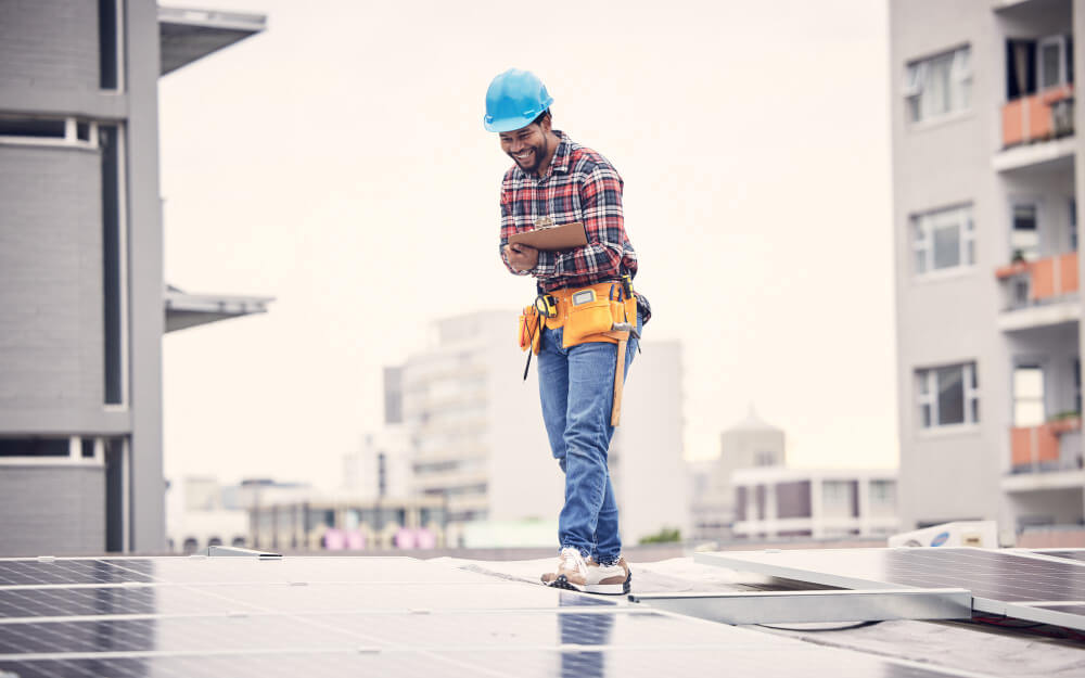 Installateur ajoutant un nouveau panneau solaire et son micro-onduleur Enphase sur des rails de montage sur un toit.