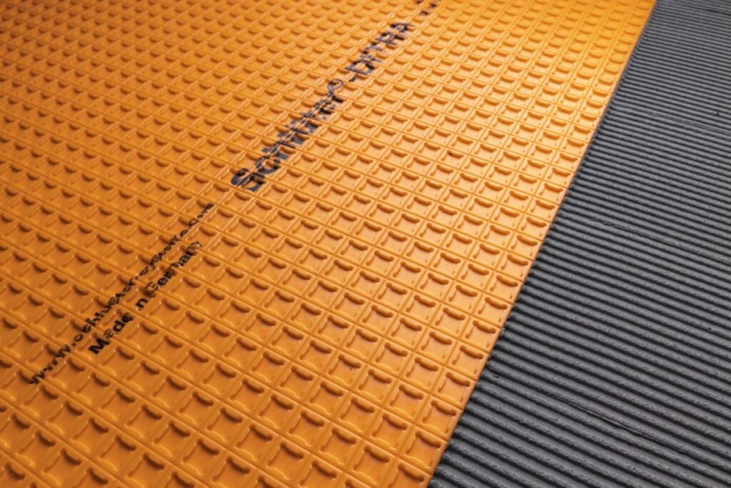 Carrelage sur OSB : pourquoi utiliser une natte de désolidarisation ? 2 Pose d'une natte de désolidarisation orange (type Ditra)