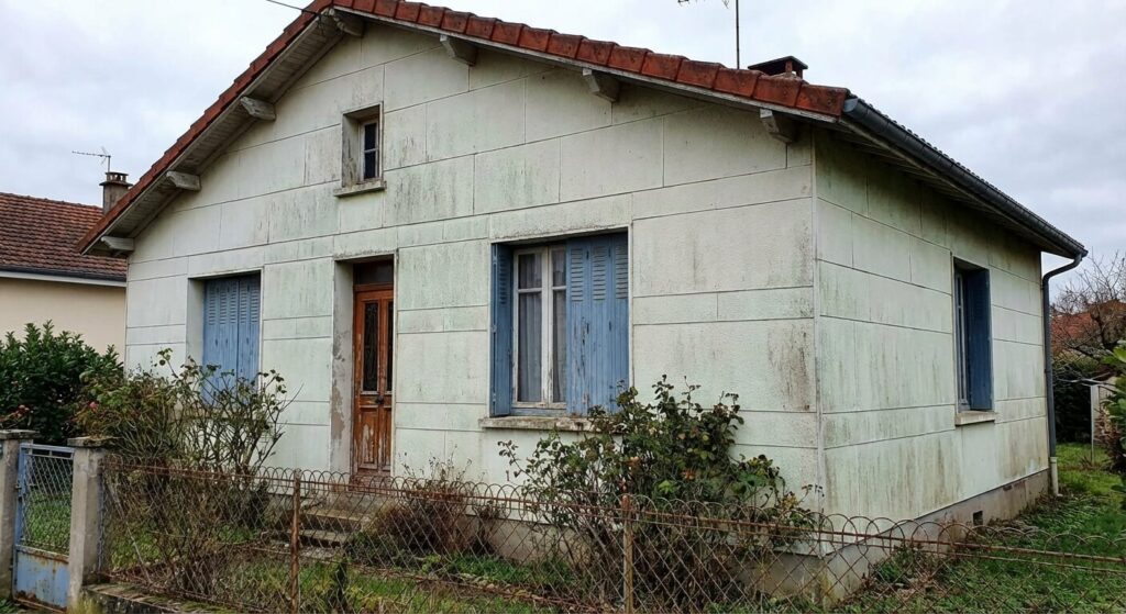Amiante dans une maison Phénix : Où se cache-t-il et que faire ? 2 Façade typique d'une ancienne maison Phénix avec des plaques extérieures en fibrociment pouvant contenir de l'amiante