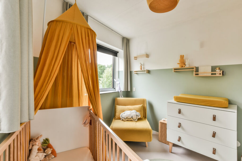 Chambre enfant : comment bien l'aménager de 0 à 12 ans 2 Un berceau en bois et des rangements bas adaptés à l'autonomie d'un jeune enfant.