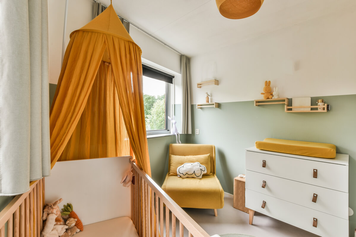 Un berceau en bois et des rangements bas adaptés à l'autonomie d'un jeune enfant.