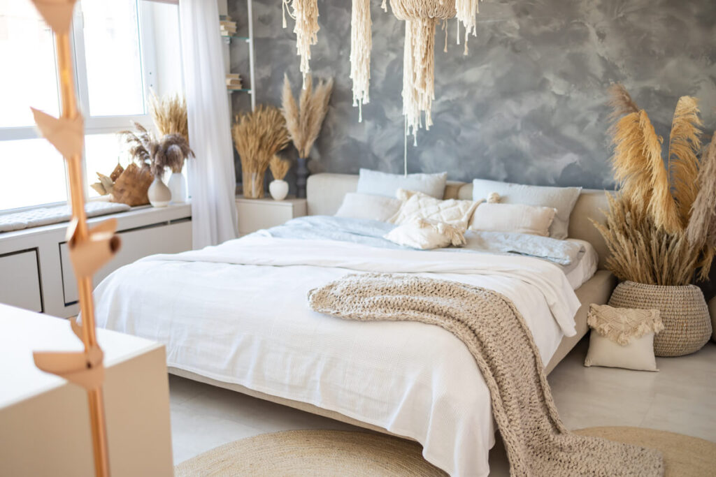 Un grand lit confortable avec des draps en lin froissé et des coussins moelleux dans une chambre d'adulte.