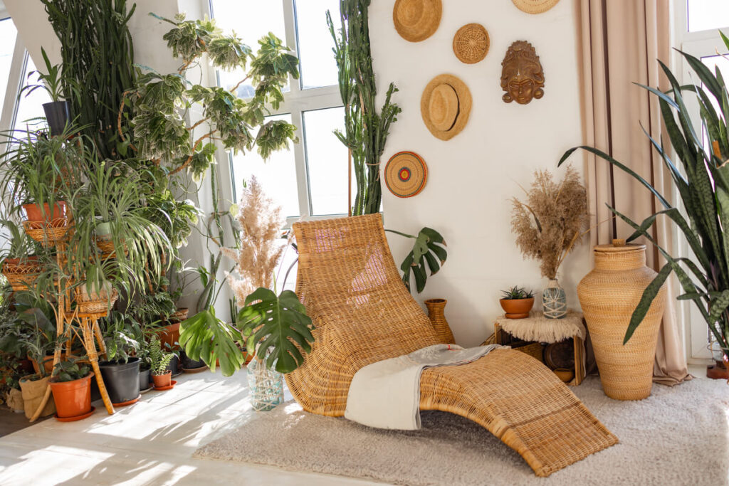 Comment aménager un espace détente autour d’un transat ? 3 Un transat en toile tressée entouré de plantes vertes et de ganivelles en bambou pour créer un cocon d'intimité.
