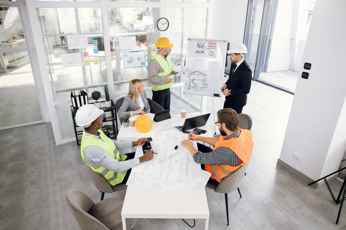 Réunion de chantier entre un maître d'œuvre et différents corps d'état pour l'organisation des travaux de gros œuvre.