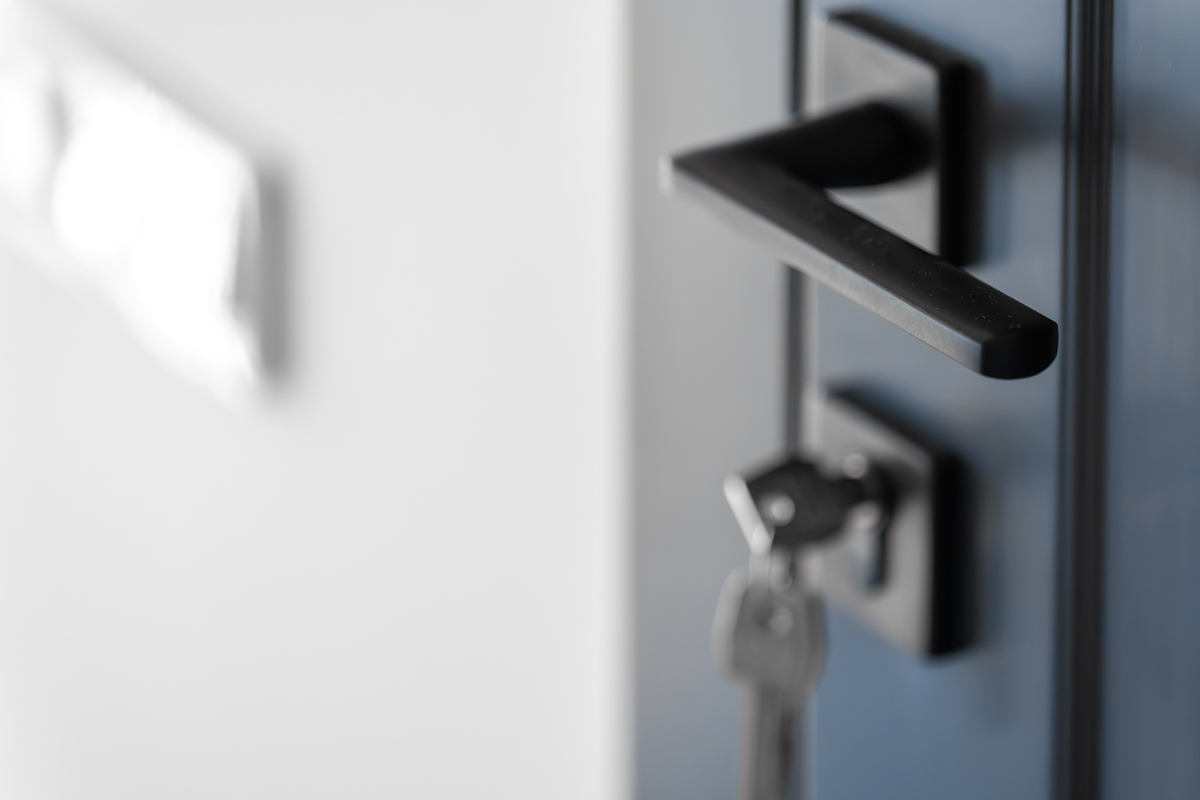 Gros plan sur une poignée de porte fermée illustrant une situation de porte claquée avec les clés restées à l'intérieur.