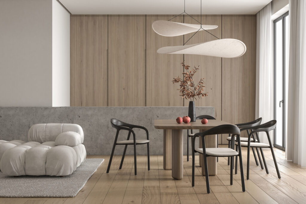 Une élégante suspension design installée au-dessus d'une table à manger en bois massif.