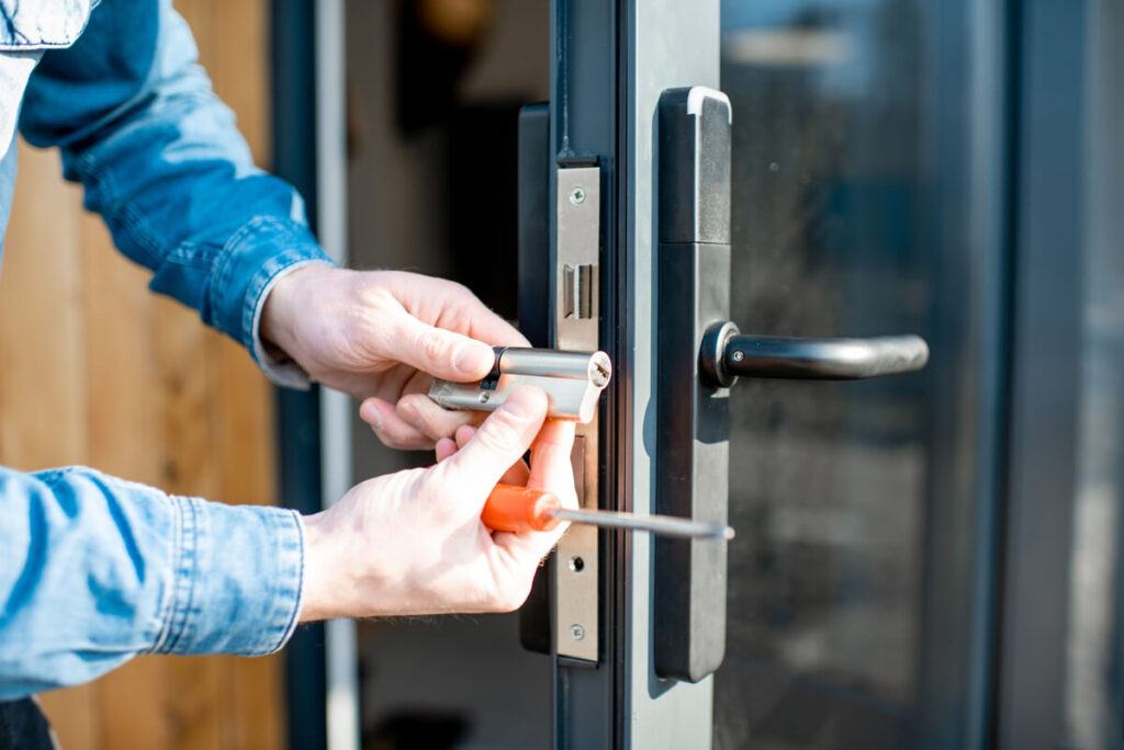 Un artisan serrurier utilisant des outils professionnels pour ouvrir une porte sans endommager le mécanisme.