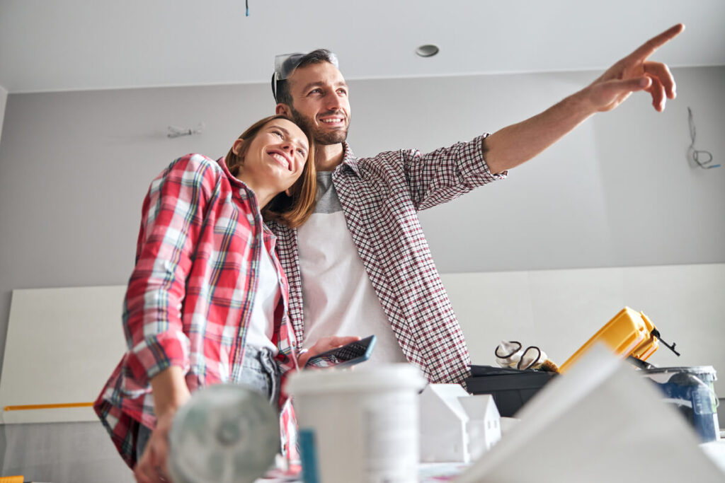 Rêver d'acheter une maison : signification et interprétations 3 Un couple souriant visitant les pièces vides d'une future demeure en cours d'acquisition.