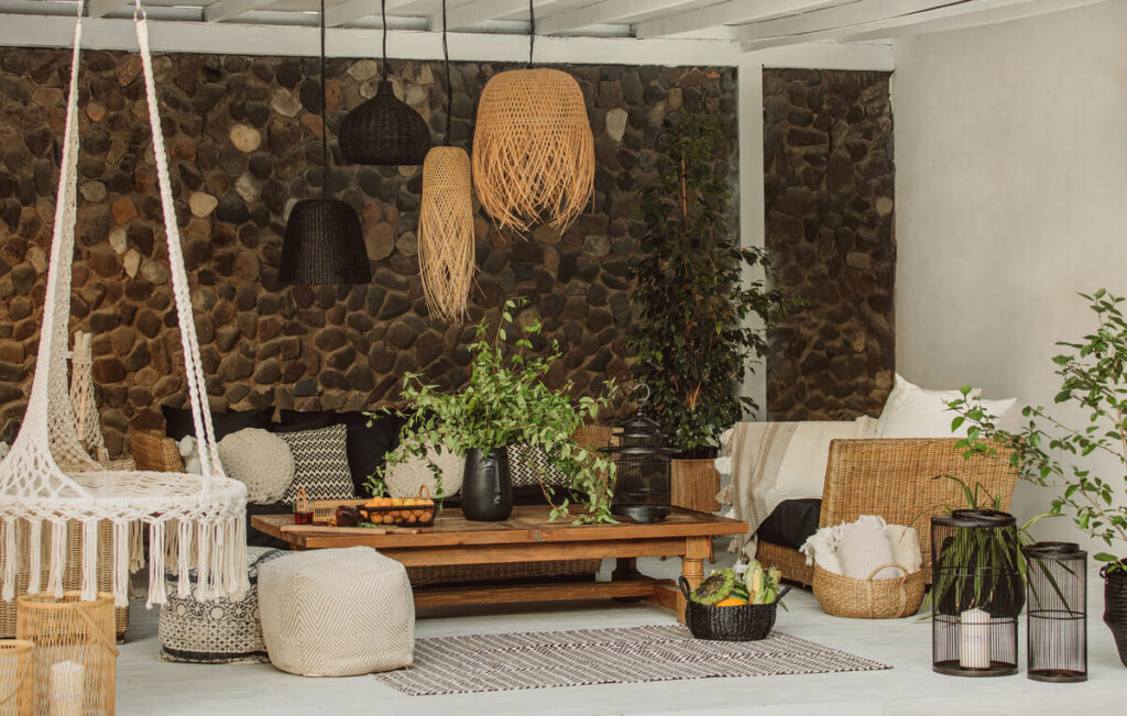 Une terrasse en bois aménagée pour l'été avec un salon de jardin design et des plantes exotiques.