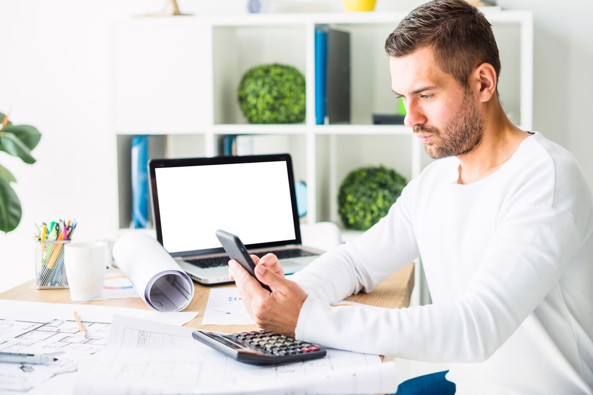Un propriétaire bailleur consultant le tableau de bord de son outil de gestion locative en ligne sur un ordinateur portable.