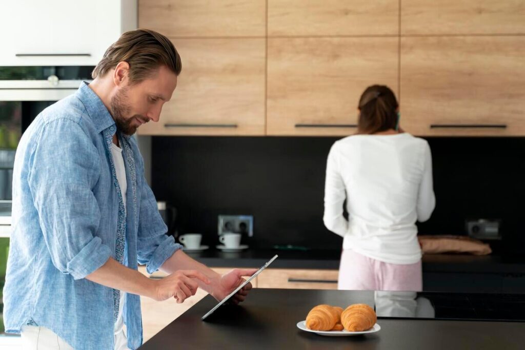 Un concepteur de cuisine dessinant les plans en 3D d'une cuisine équipée moderne.