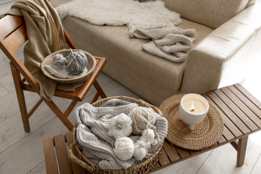 Les accessoires qui font la différence dans une déco d’intérieur 4 Un mélange de coussins en lin et d'un plaid en laine bouclée disposés sur un canapé.