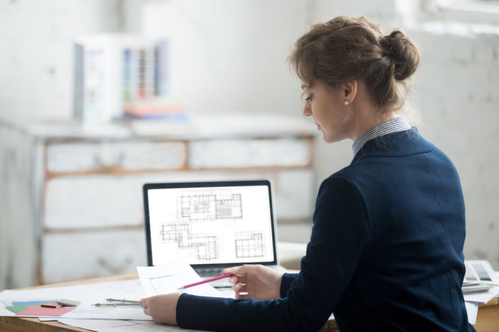 Les compétences indispensables d’un architecte d’intérieur 2 Un architecte d'intérieur concevant les plans en perspective 3D d'une maison sur son logiciel informatique.