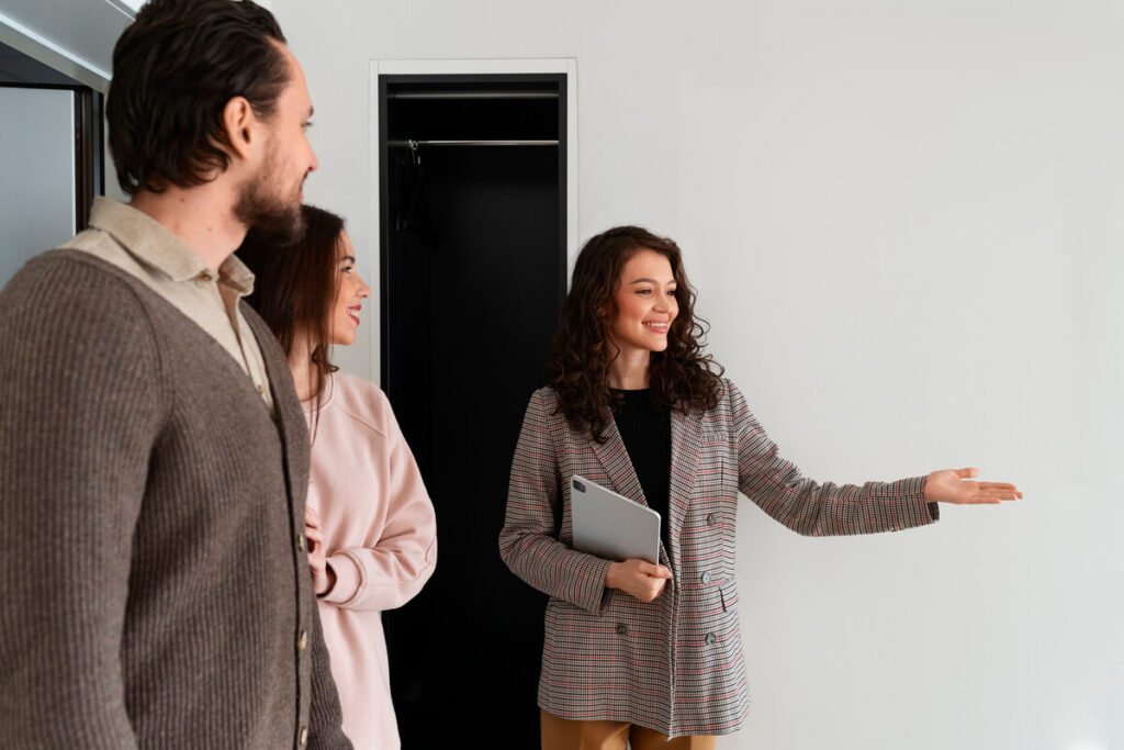 Certificat PEB : comment retrouver et vérifier celui d'un logement en Belgique 3 Un agent immobilier présentant le score PEB d'un appartement lors d'une visite avec des acheteurs.