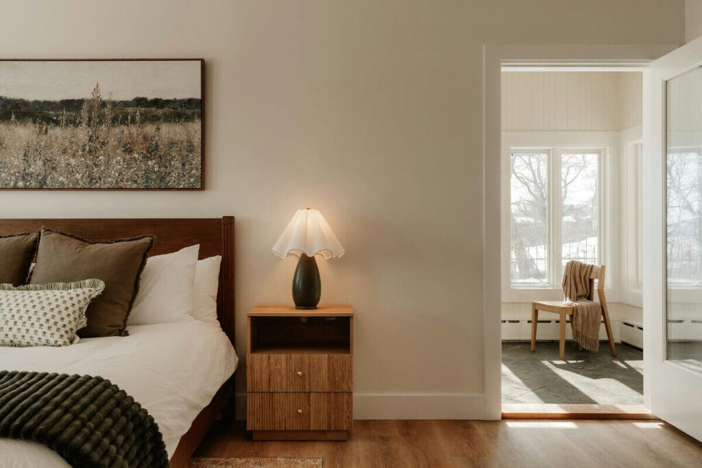Chambre à coucher lumineuse décorée de plantes vertes d'intérieur posées près d'une fenêtre.