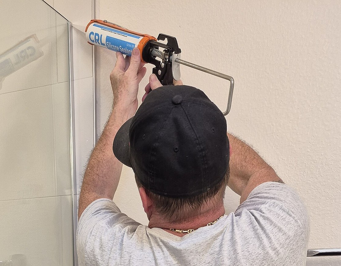 Scellant appliqué sur la jonction d'une enceinte de douche : chaque joint est un point d'entrée pote