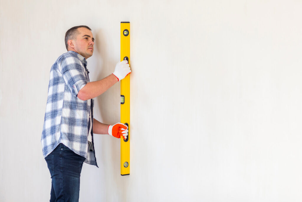 Mur pas droit dans une maison ancienne : normal ou inquiétant 2 Niveau à bulle posé sur un vieux mur en pierre montrant un important écart d'aplomb vertical.