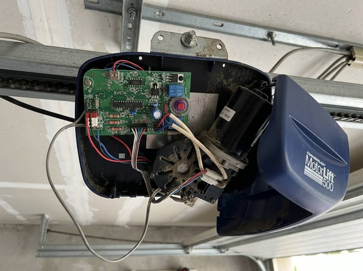 Boîtier ouvert d'une motorisation de porte de garage Chamberlain MotorLift 500 montrant la carte électronique.